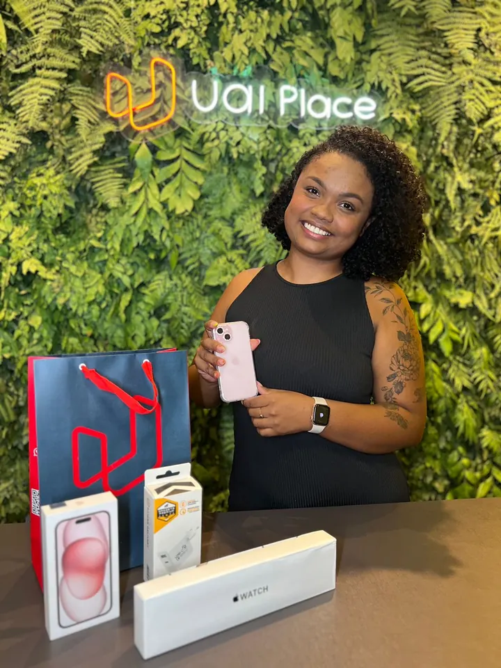 Cliente da UaiPlace com o aparelho novo e a sacola da loja