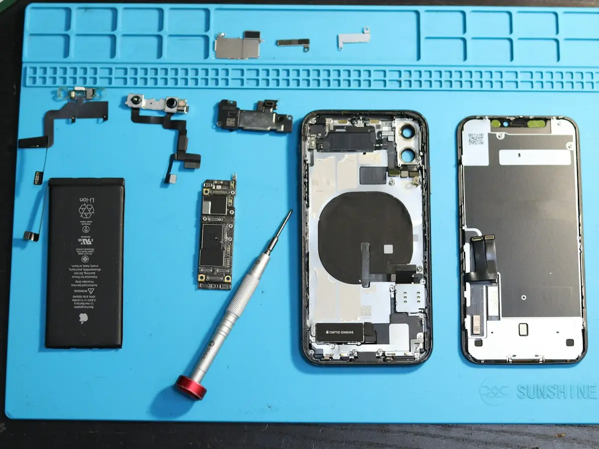 Componentes de iPhone organizados em tapete antiestático