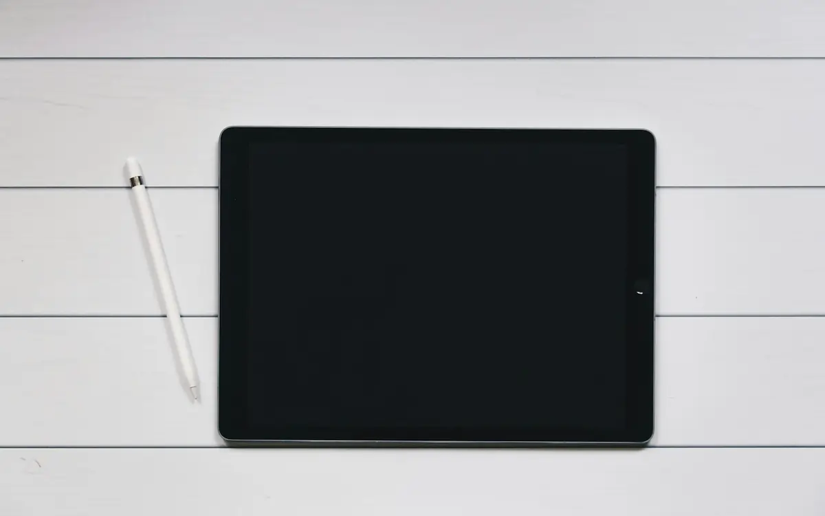 iPad com Apple Pencil sobre mesa branca