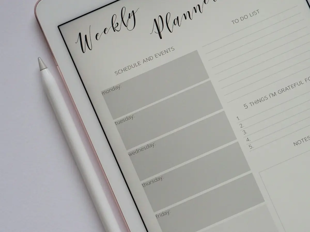 iPad com Apple Pencil e planner na tela