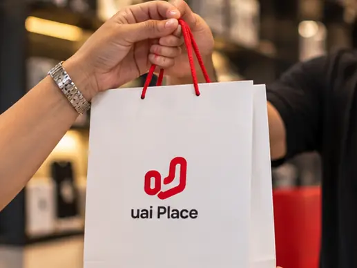 Atendente da UaiPlace entregando a sacola com o aparelho pronto ao cliente