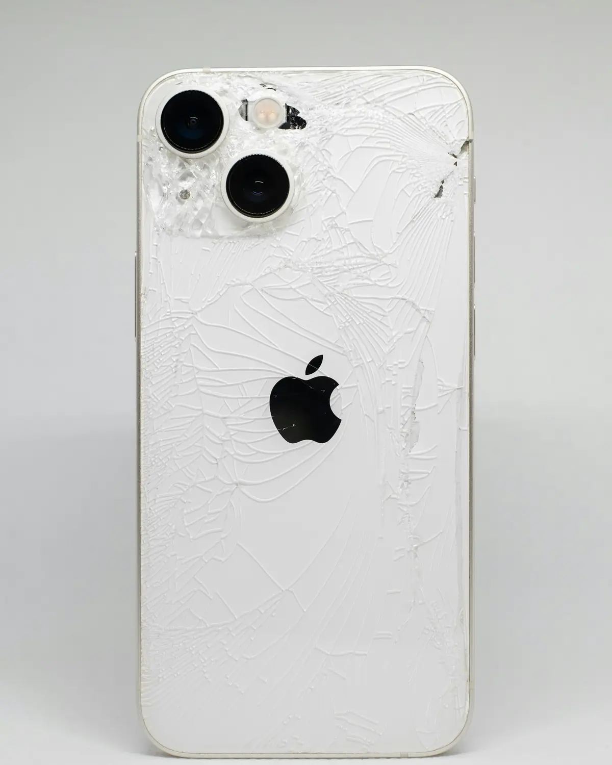 iPhone branco com o vidro traseiro trincado