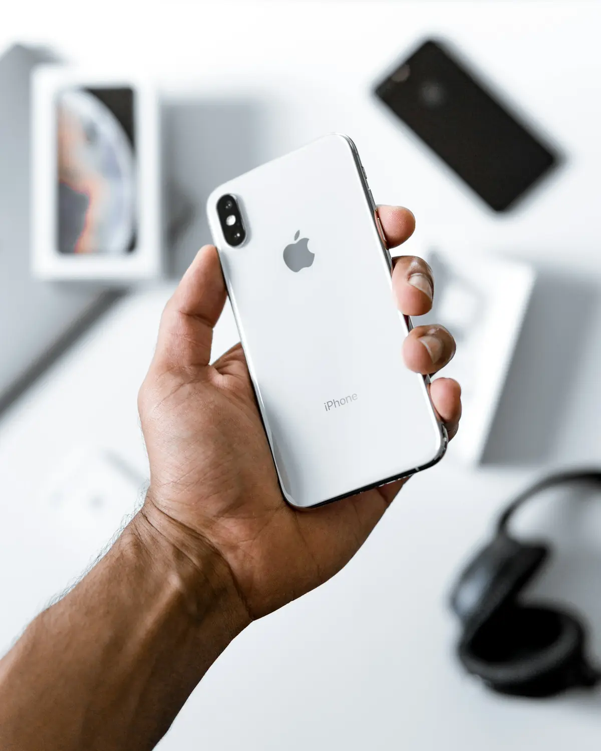 Mão segurando um iPhone prateado