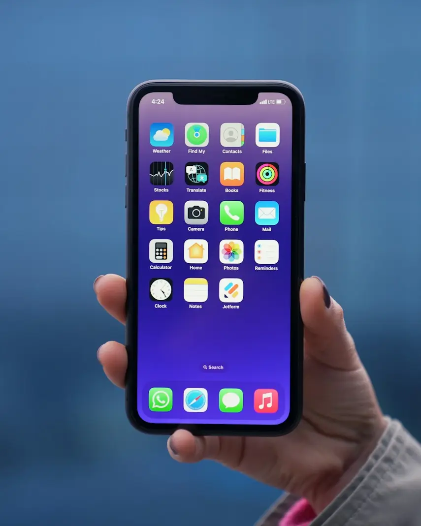 Mão segurando um iPhone com a tela ligada